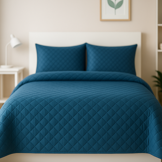 Blue quilted bedspread on a bed in a bedroom setting