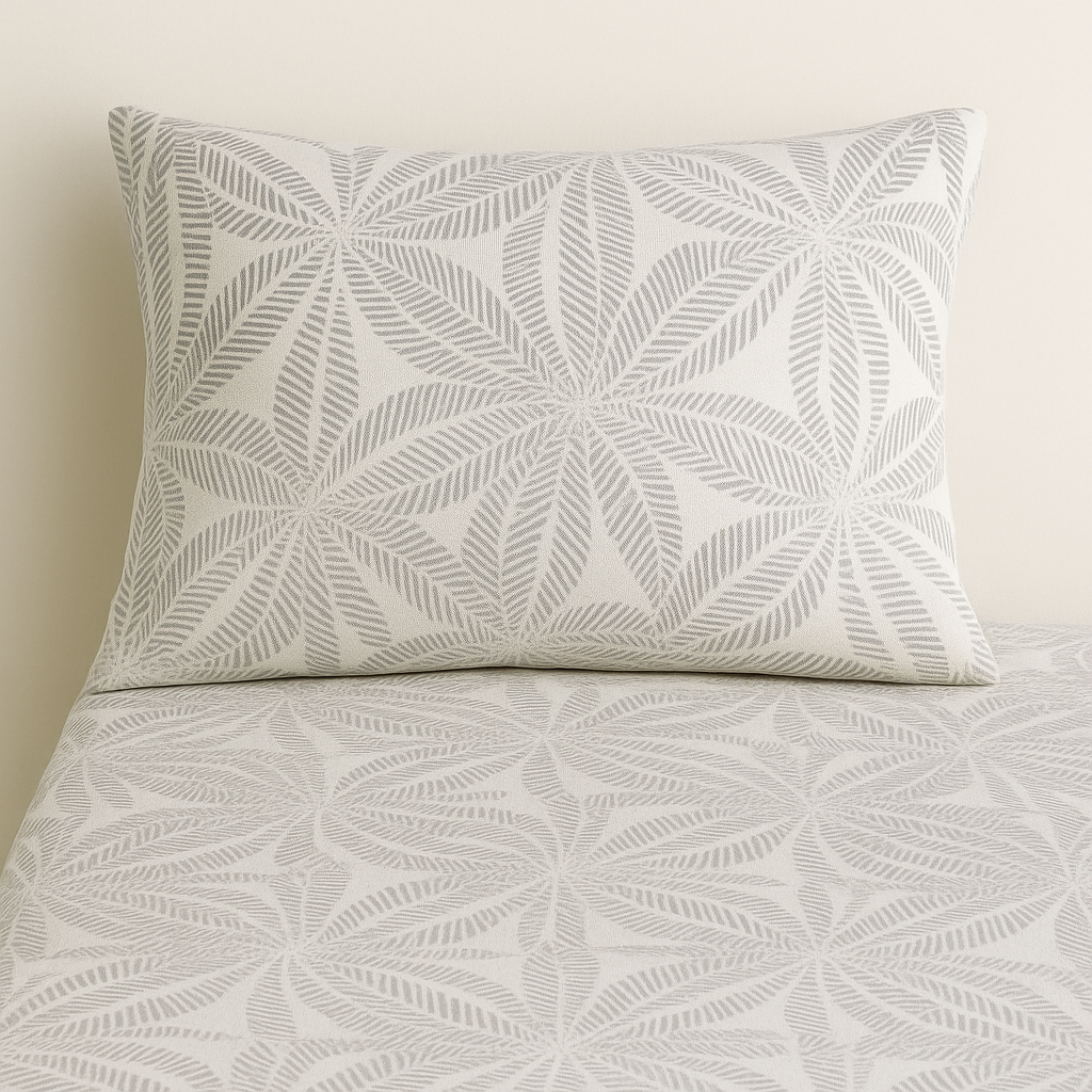 Patterned pillow and sheet set on a bed with a neutral background